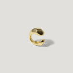 Gold open band ring with modern, sculptural design on a light background