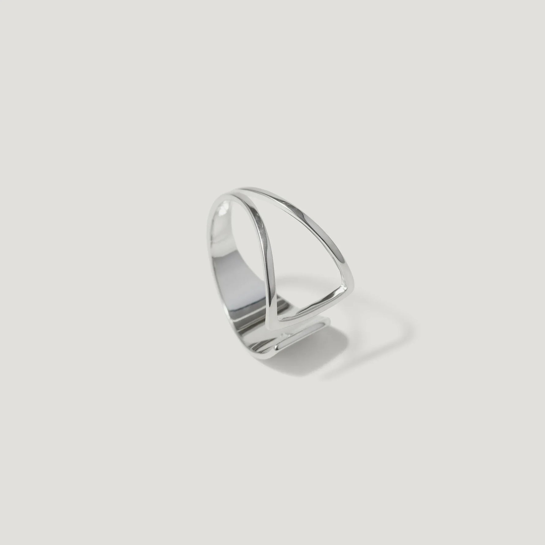 Minimalist geometric silver open band ring with modern design on white background