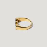 Gold geometric ring with a modern, flat-top design on a plain light background