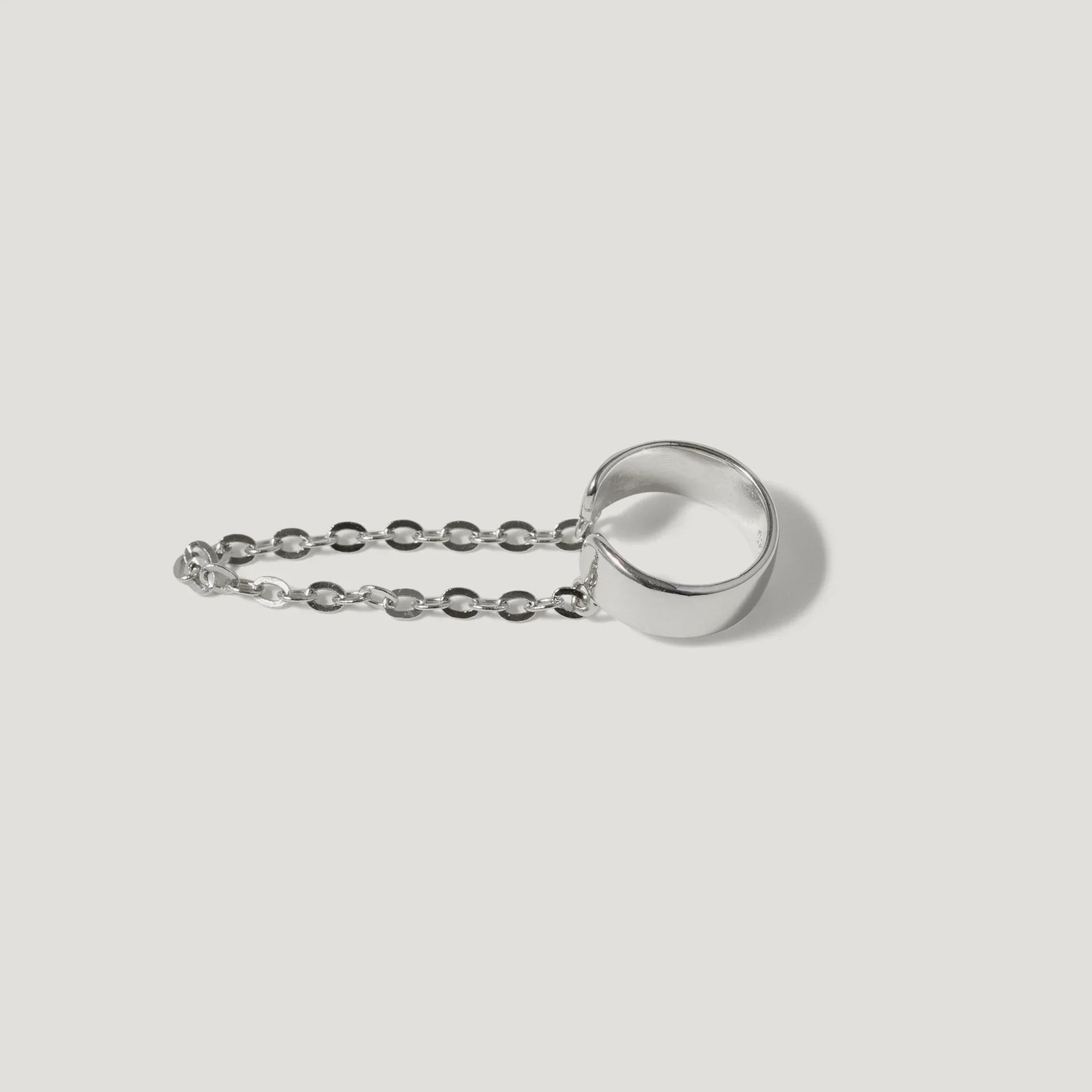 Minimalist silver chain ring on white background, modern jewelry design
