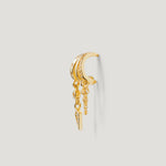 Gold ear cuff with dangling chains and crystal accents on a light background