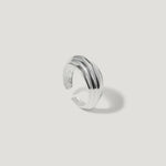 Textured silver ear cuff with grooved design on a plain light background