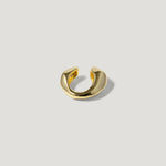 modern gold ear cuff with sculpted design on neutral background