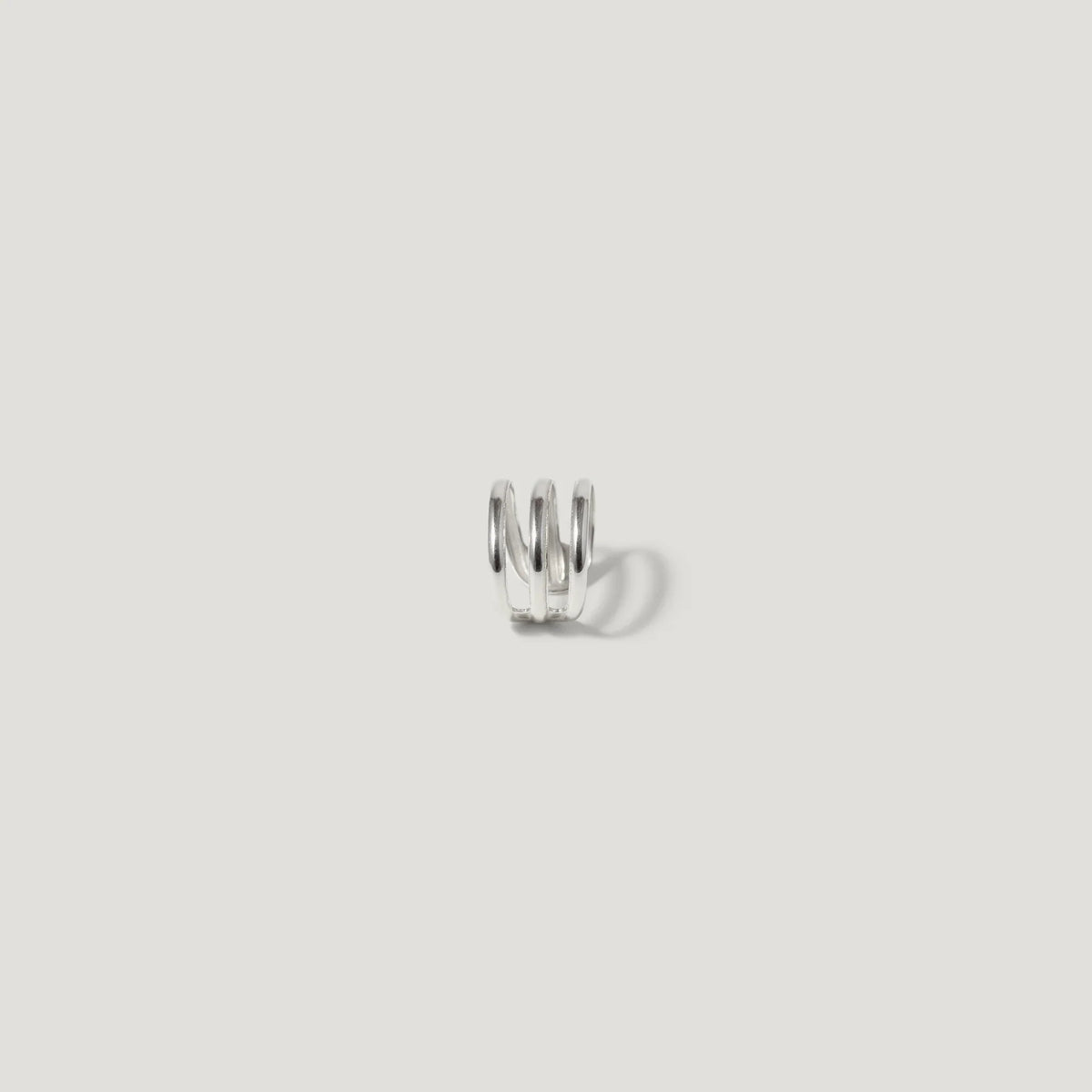 Minimalist silver spiral ear cuff on white background