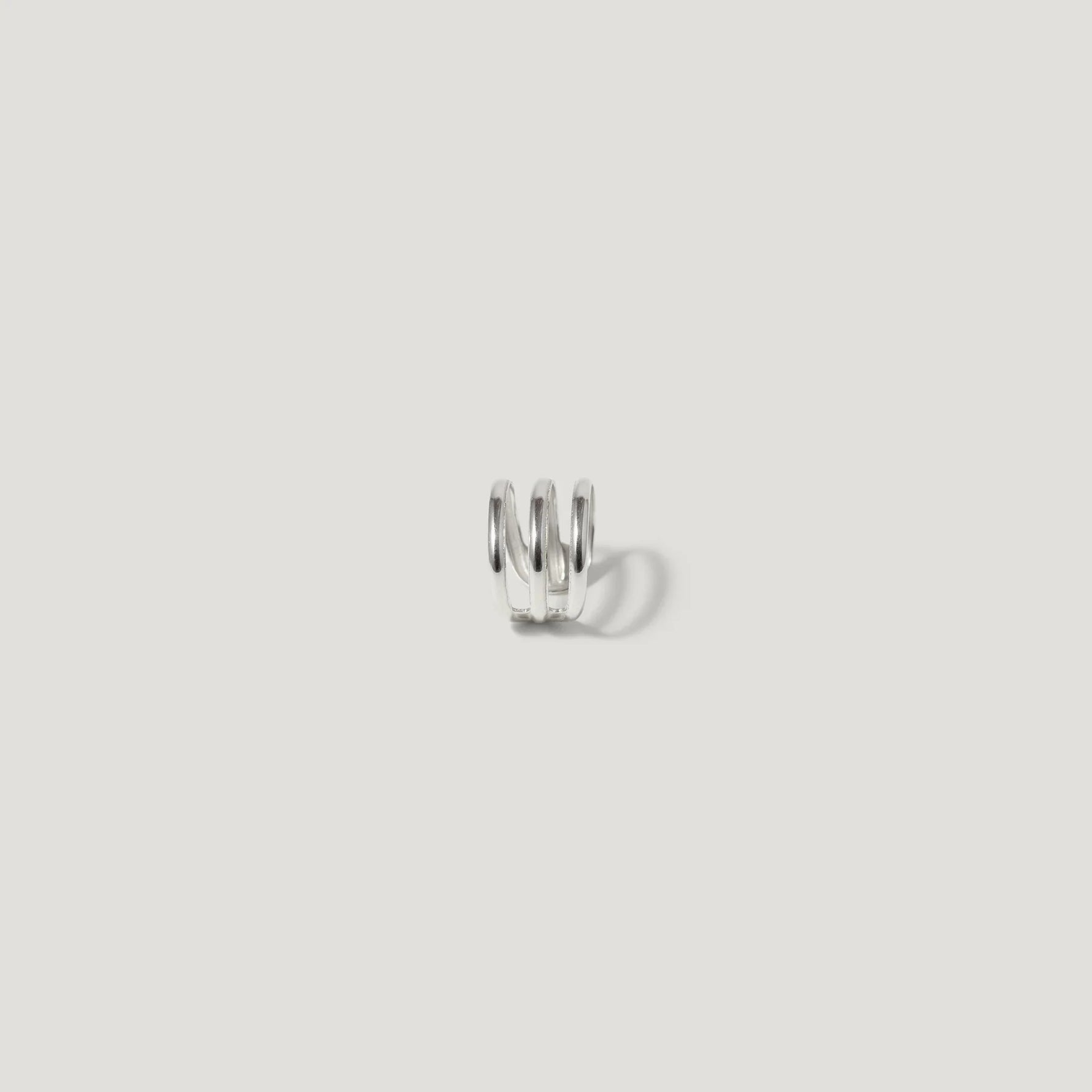 Minimalist silver spiral ear cuff on white background