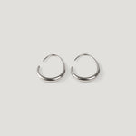 Silver tapered open hoop earrings with thin wire posts, on light background