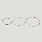 Three silver hoop earrings in ascending sizes, thin wire with clasp closures, side by side.