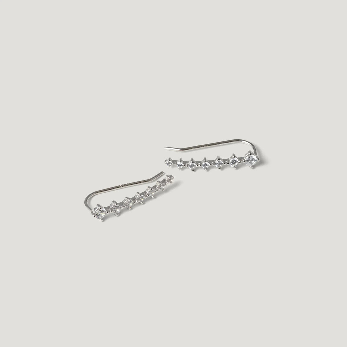 Sterling silver ear climber earrings with clear gemstones on a white background