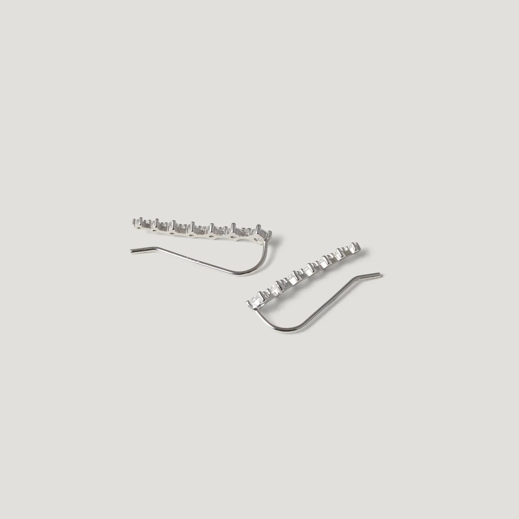 Sterling silver crawler earrings with geometric stone settings on light background
