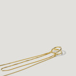 Minimalist gold necklace with two interlocking textured rings on a white background