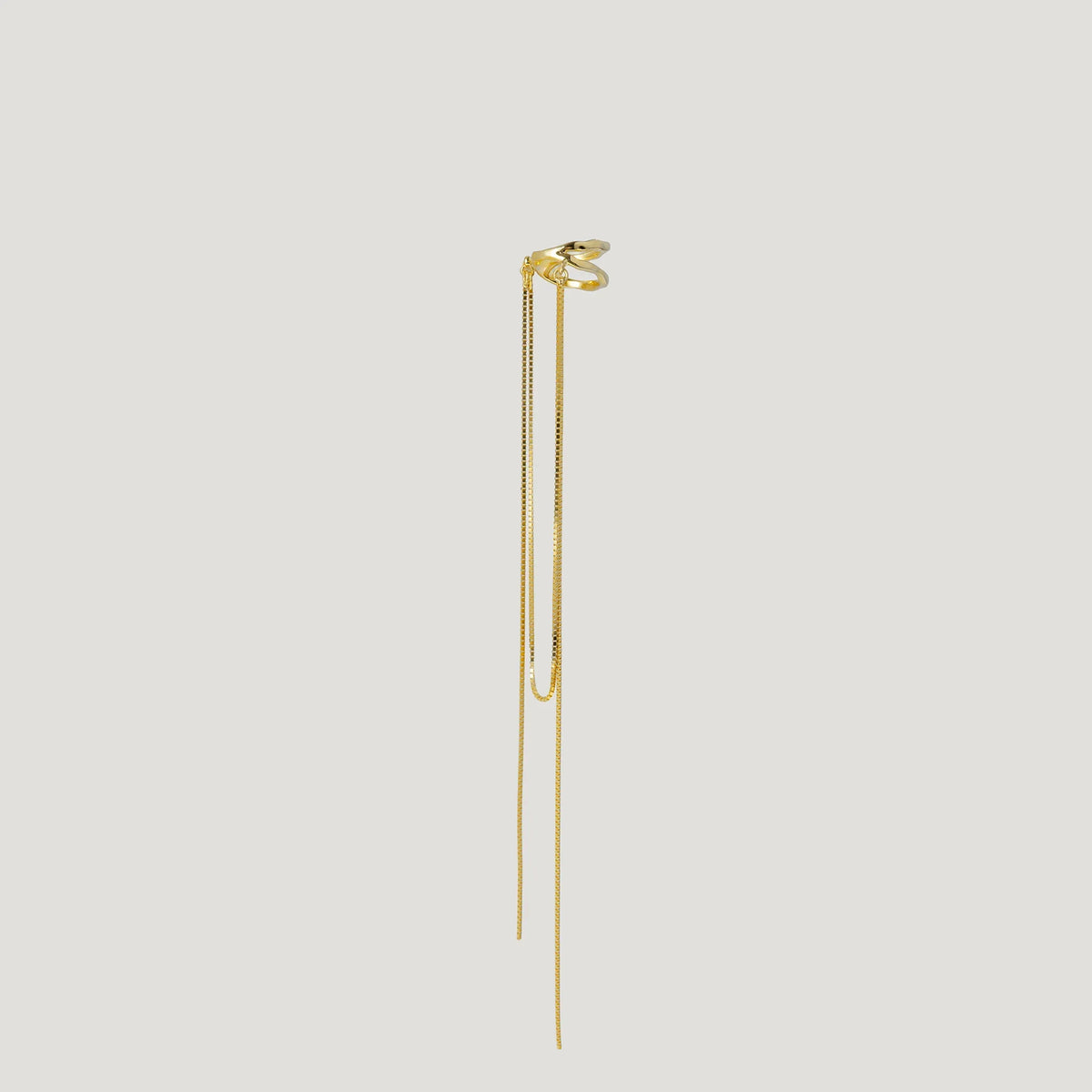 Minimalist gold ear cuff with long dangling chains on white background