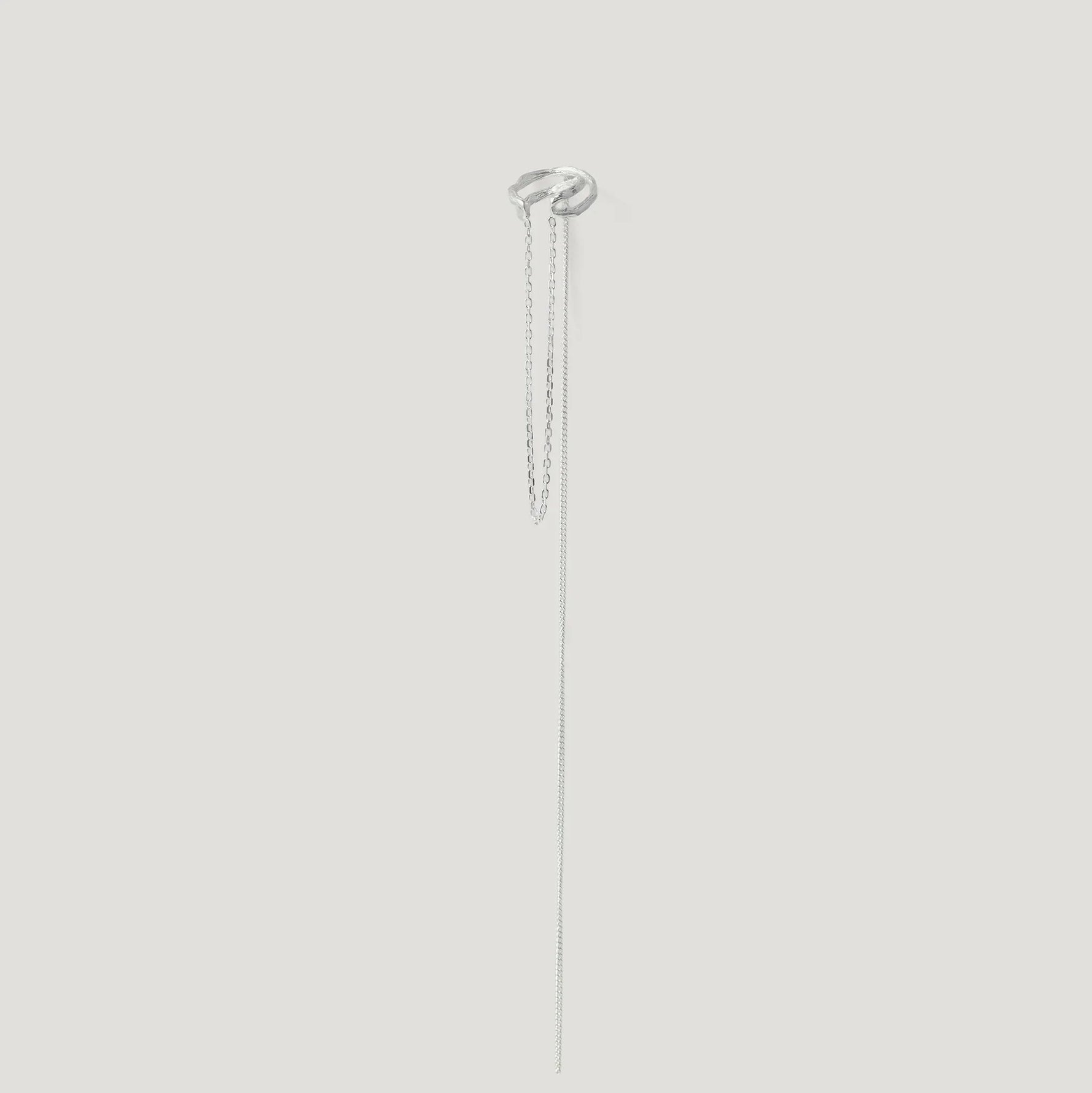 Minimalist silver ear cuff with two delicate dangling chains on white background