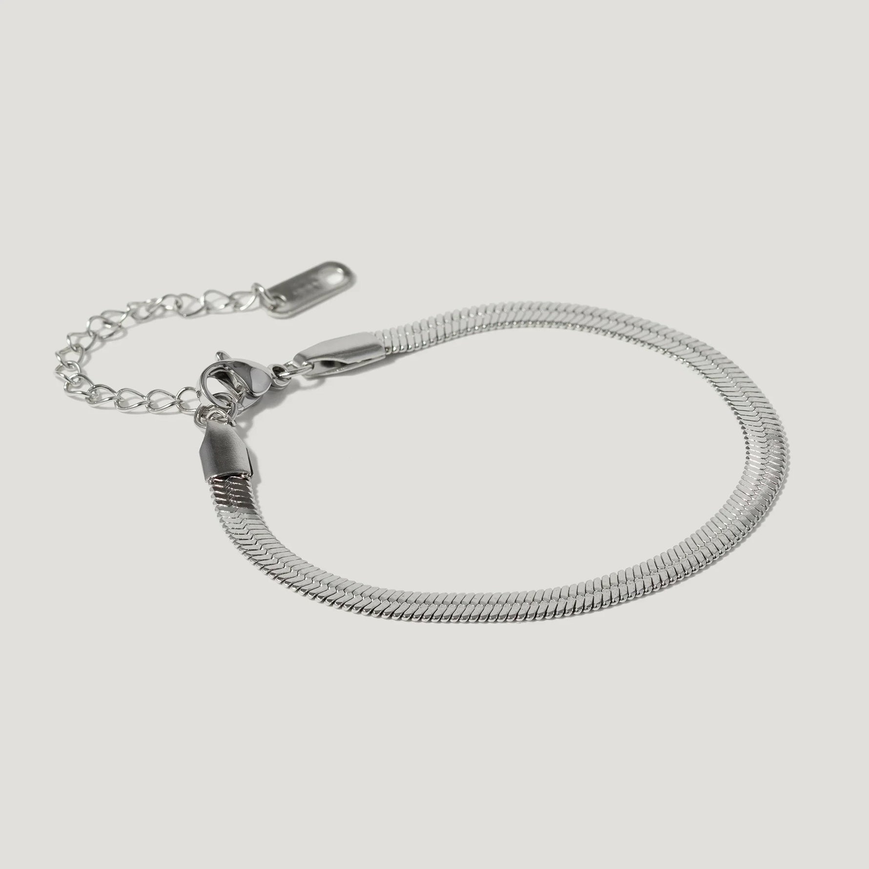 Silver snake chain bracelet with adjustable clasp on white background