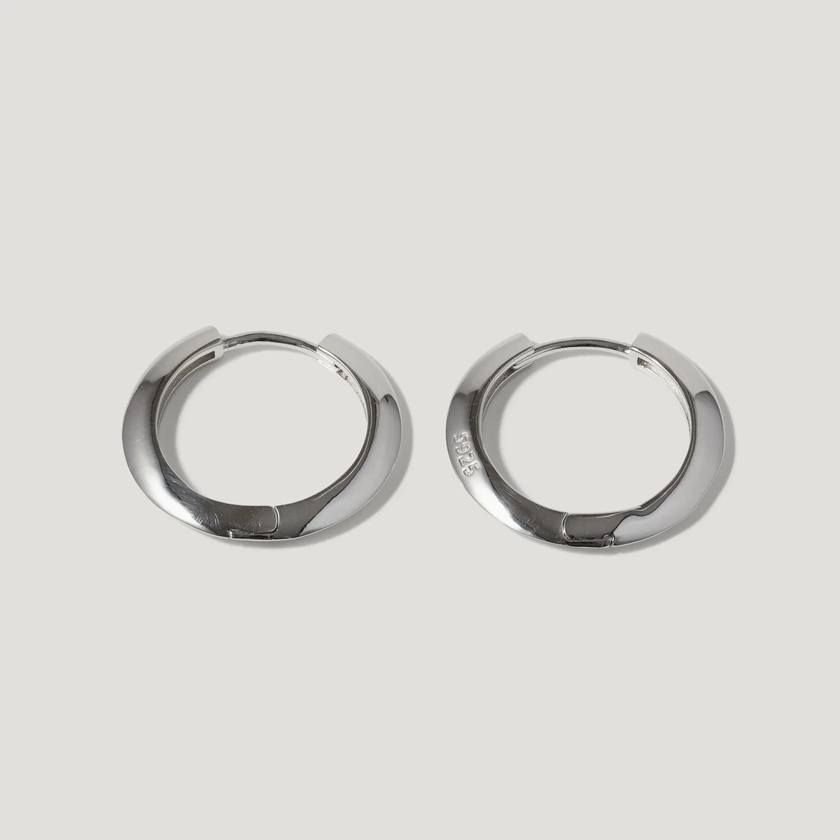 Pair of silver-tone hoop earrings with a smooth, polished finish on white background