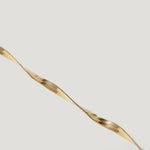 Close-up of a twisted gold herringbone chain necklace on a white background