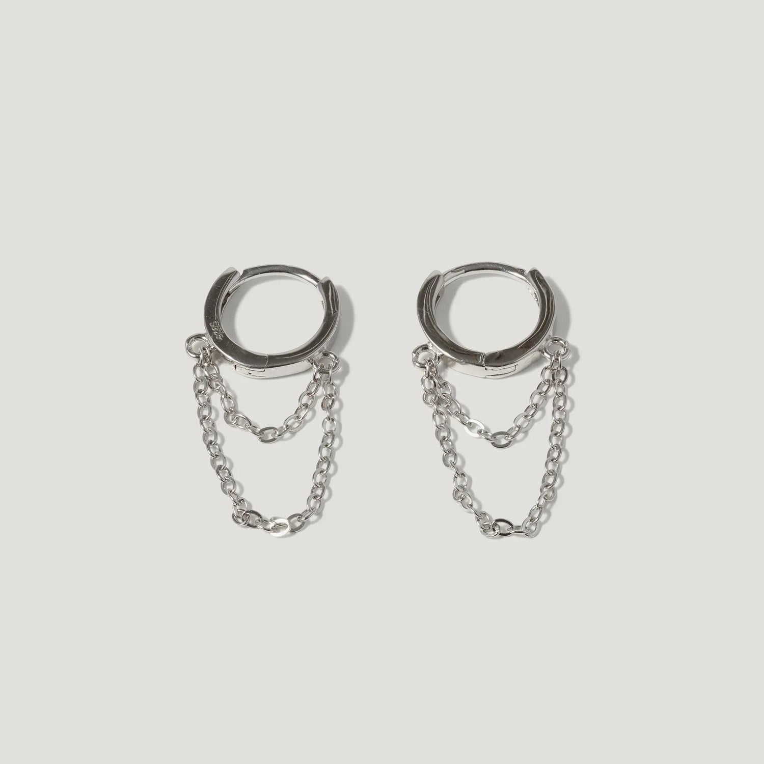 Silver hoop earrings with double chain detail on white background