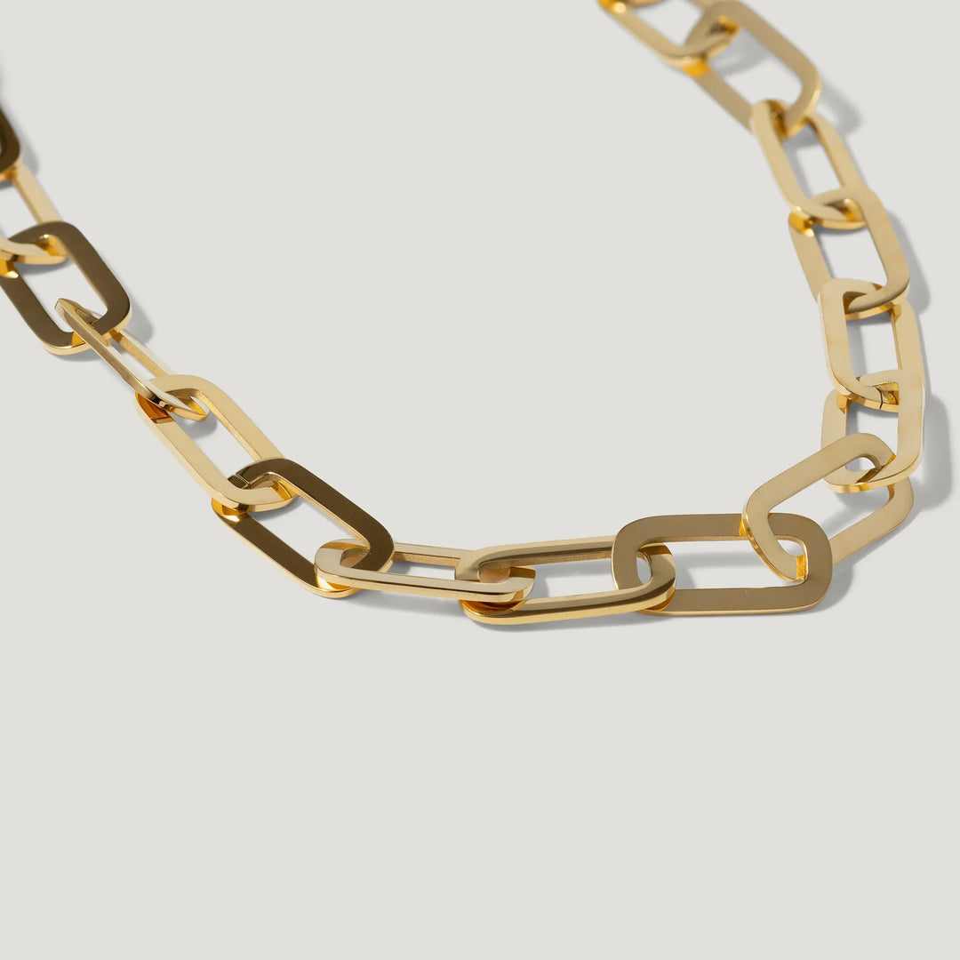 Gold chain necklace with large rectangular links on a light background