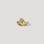 Twisted gold ring with modern sculptural design on white background