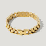 Gold link bracelet with rectangular and curved segments on a plain light background