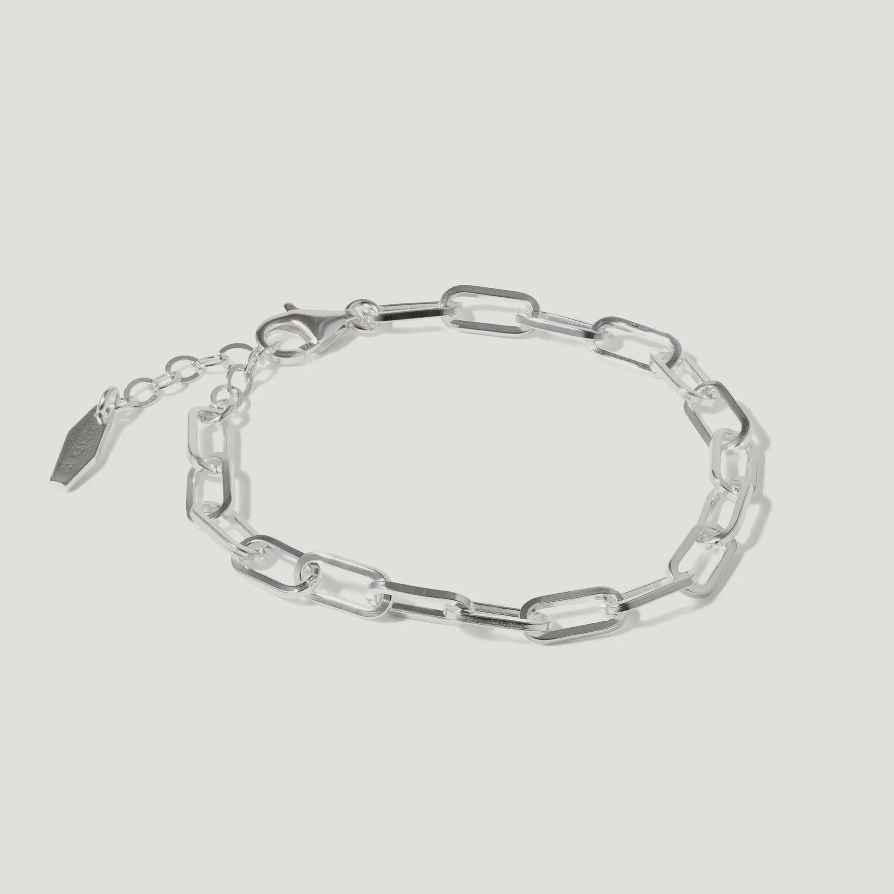 Silver chain link bracelet with adjustable clasp on white background