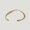 Minimalist gold open cuff bracelet with smooth, curved design on white background
