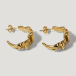 Pair of textured gold hoop earrings with organic, sculptural design on white background