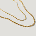 Gold rope chain necklace with twisted design on white background