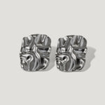 Pair of modern silver sculpted stud earrings with an abstract, wavy design on white background