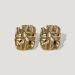 Pair of gold-tone abstract sculpted stud earrings on a light background