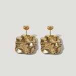 Pair of gold-tone statement earrings with abstract, wavy square design on plain background