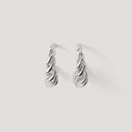 Pair of twisted silver hoop earrings on a plain white background