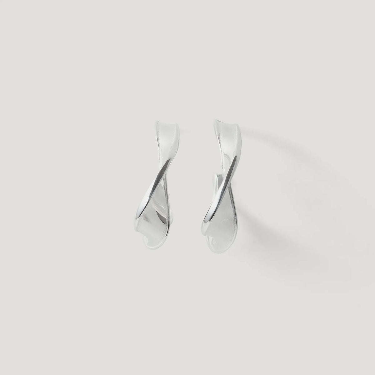 Pair of twisted silver hoop earrings on a plain white background