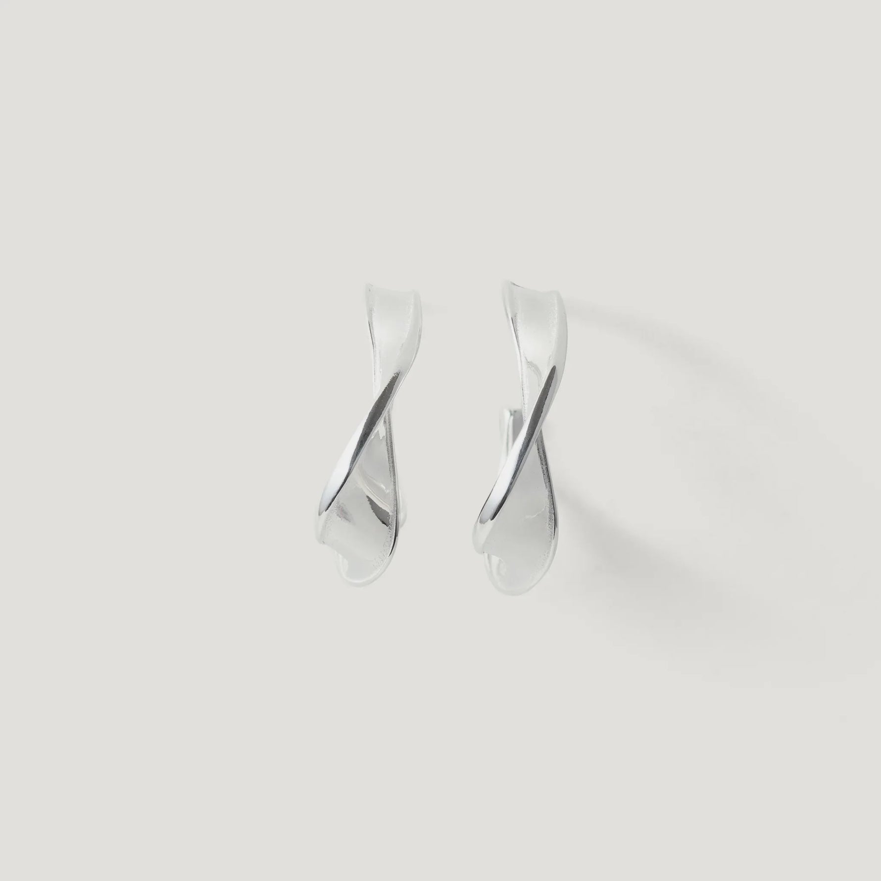 Pair of twisted silver hoop earrings on a plain white background