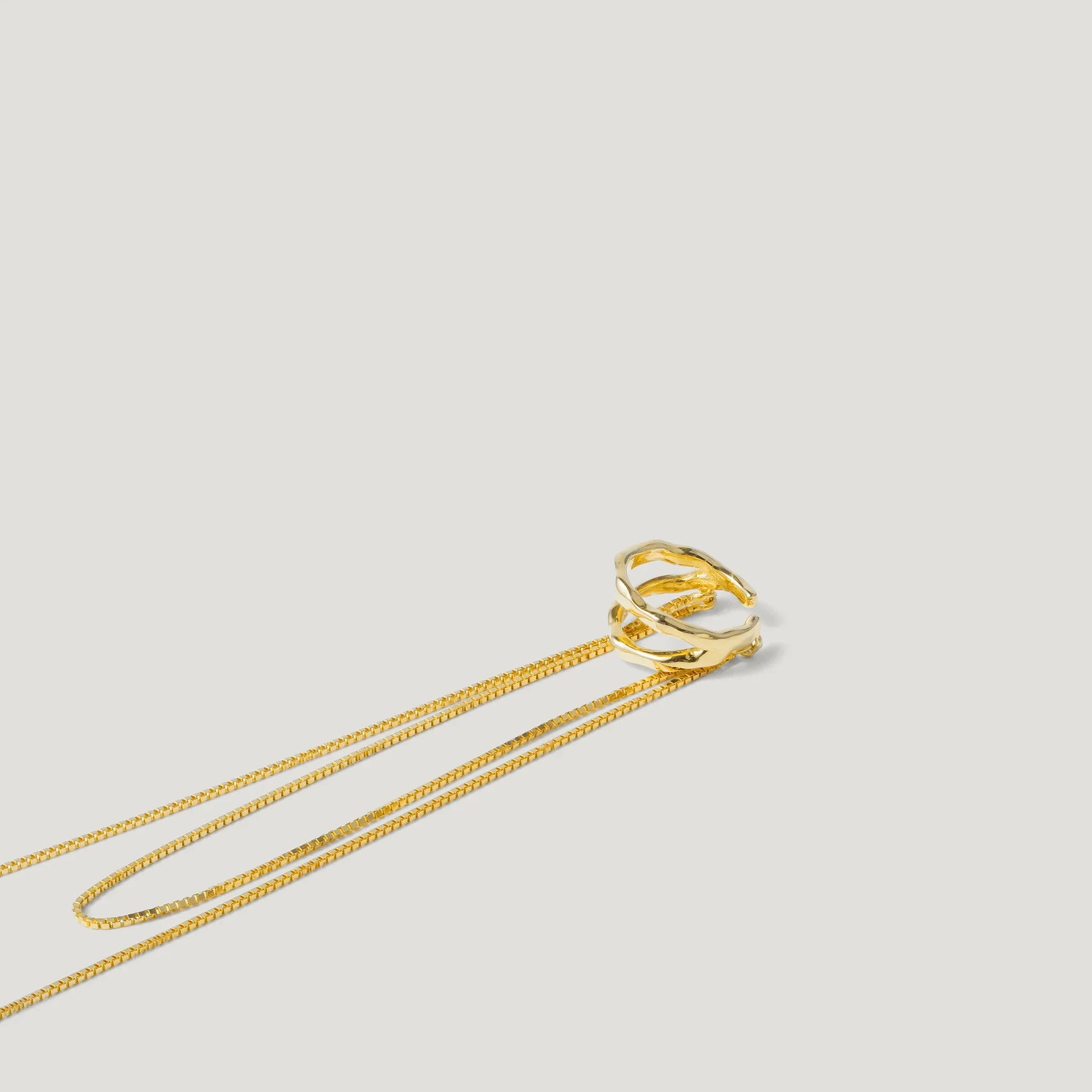 Gold twisted pendant necklace with delicate chain on white background