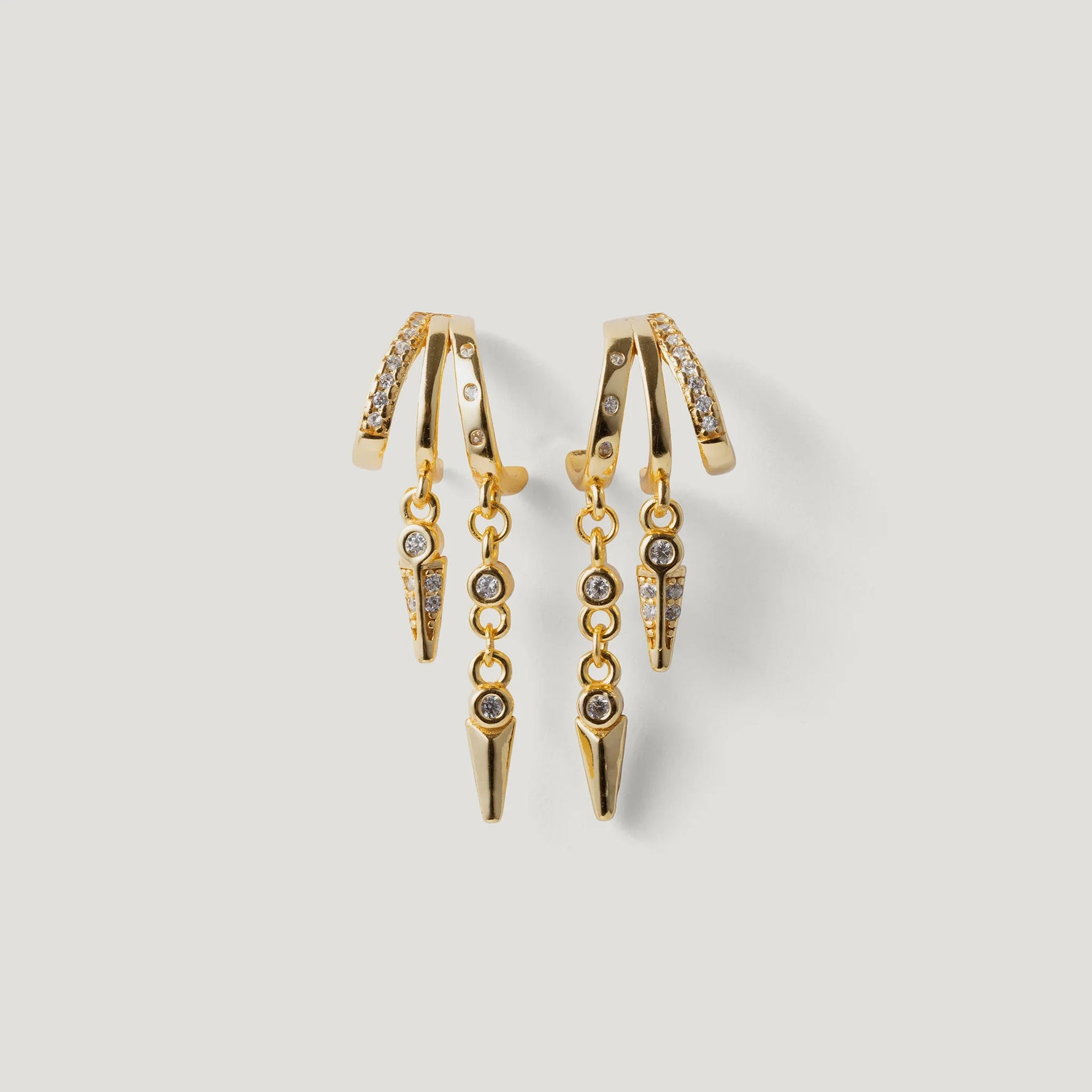 Gold drop earrings with chain and crystal accents on a white background