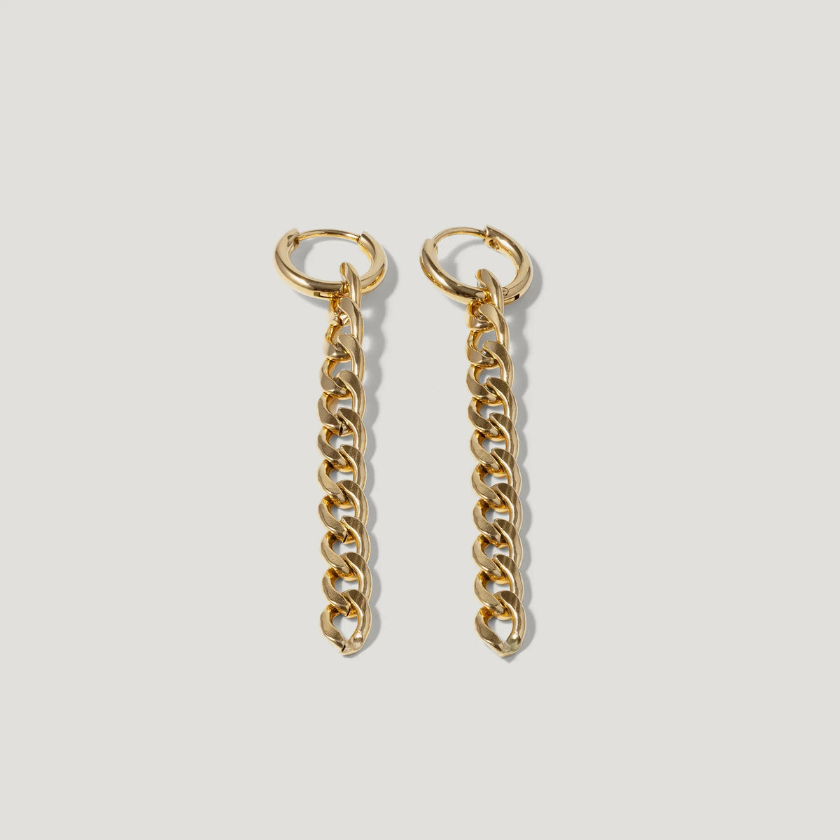 Pair of gold chain link drop earrings on a white background