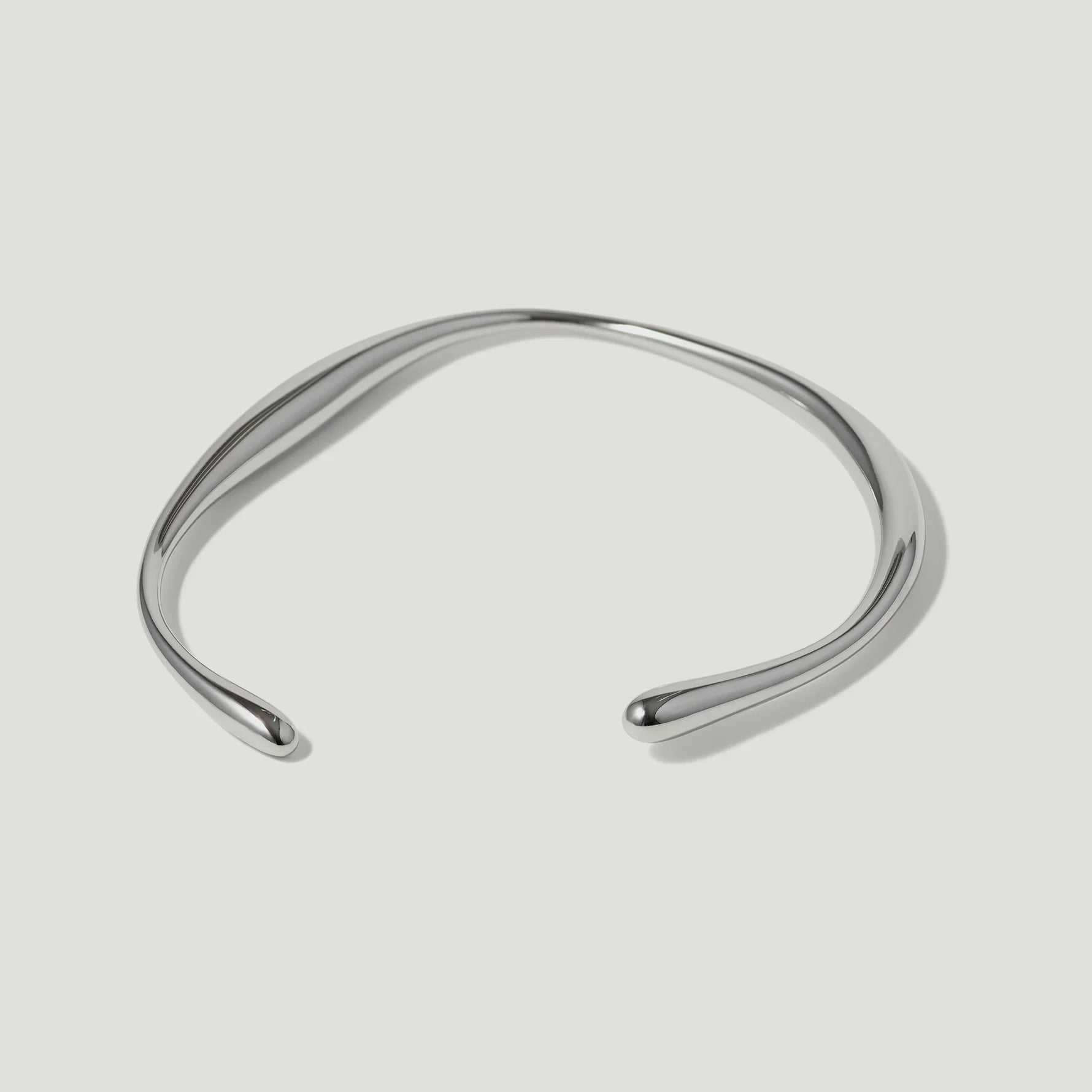 Minimalist silver open cuff bracelet with smooth polished finish on white background
