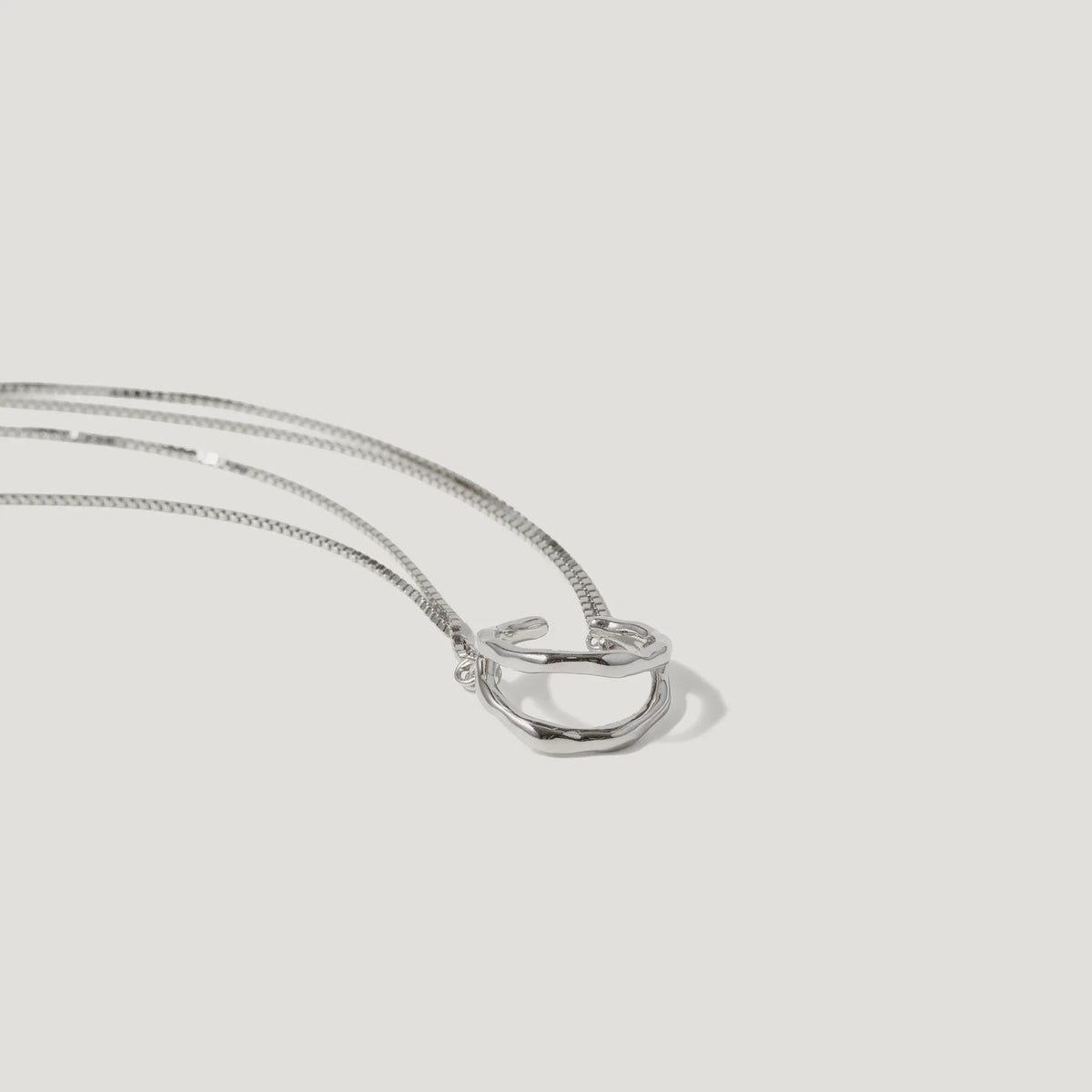 Minimalist silver ring pendant necklace with sleek chain on white background