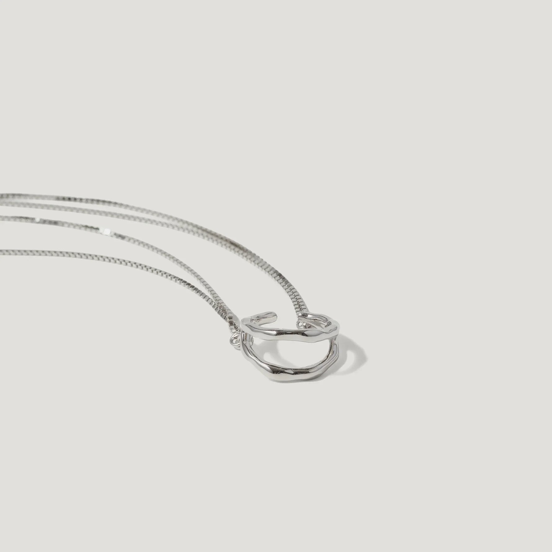 Minimalist silver ring pendant necklace with sleek chain on white background