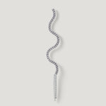 Curved silver diamond earring with wavy design on a light background