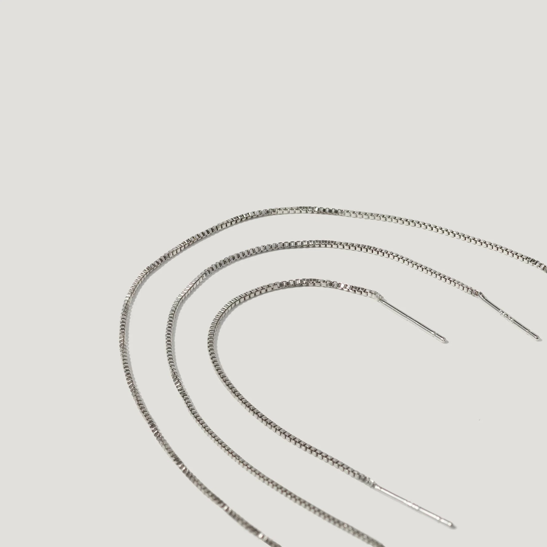 Silver box chain threader earrings on a white background