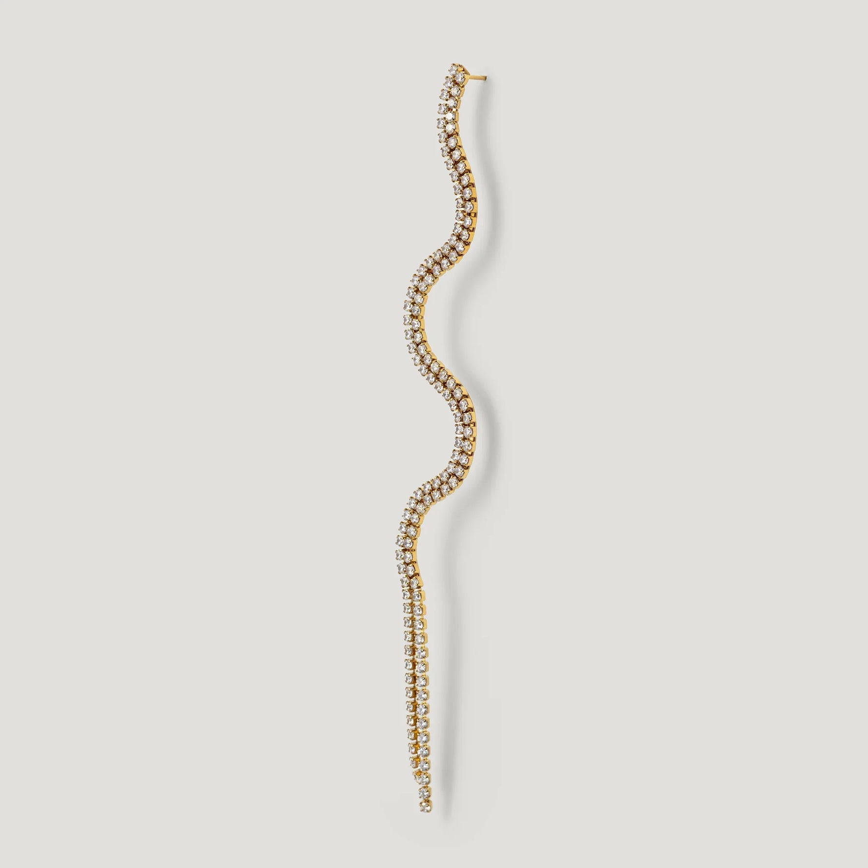 Gold wavy diamond stud earring with curved shape on white background
