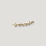 Gold ear climber earring with multiple round clear stones on a light background