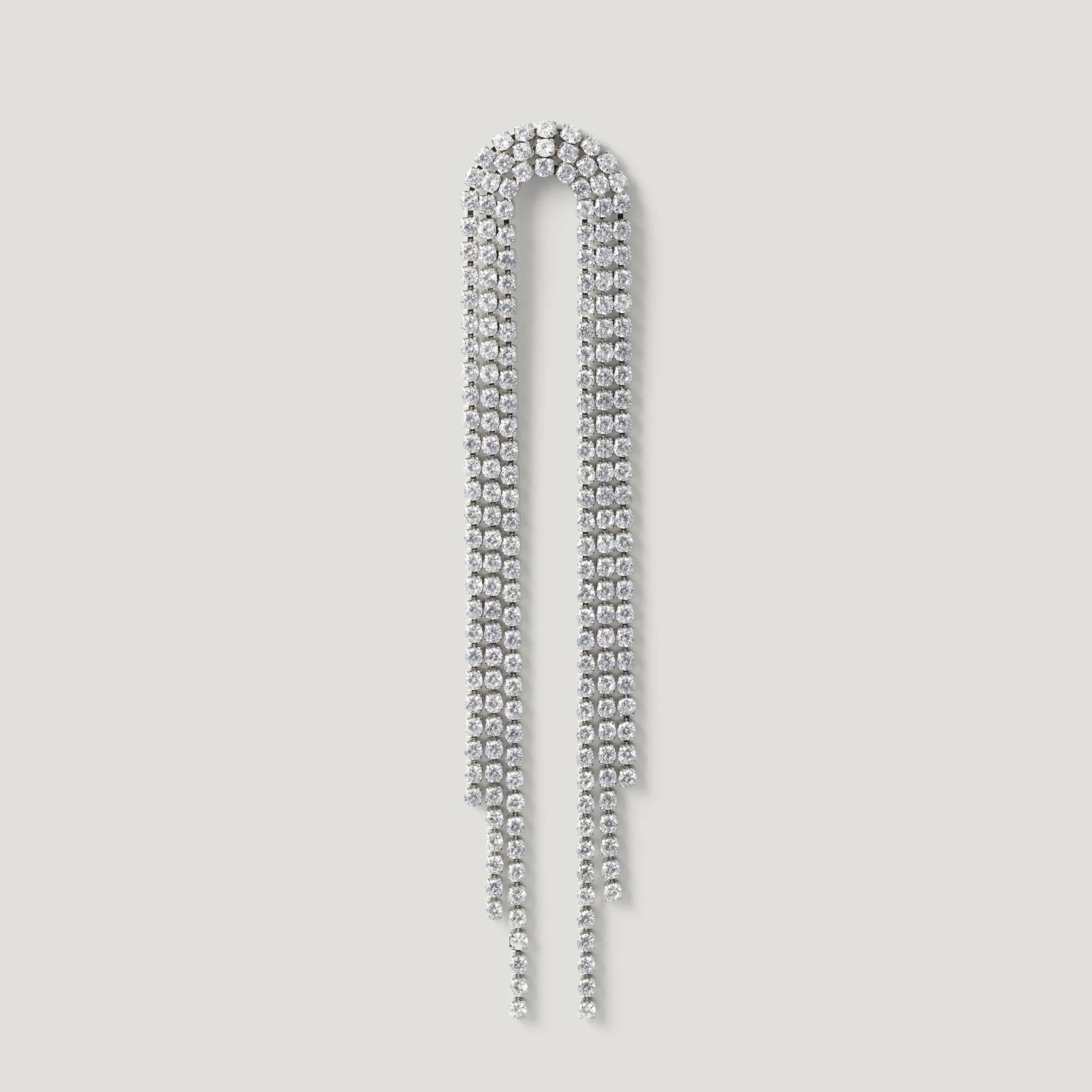 Long silver rhinestone drop earring with curved top and cascading strands on light background