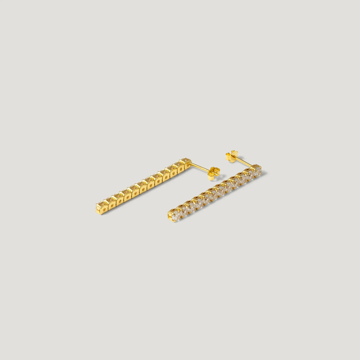 Gold bar stud earrings with clear gemstones on a light background