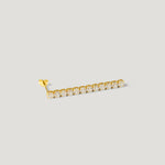 Gold ear climber earring with a row of round sparkling stones on a light background