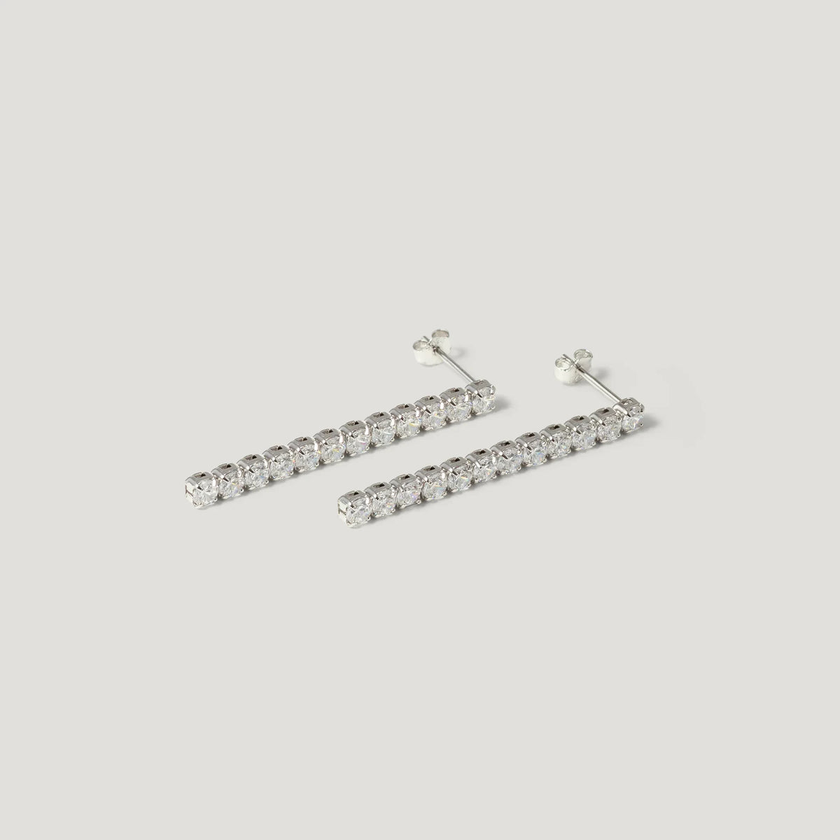 Silver bar stud earrings with clear round gemstones on white background