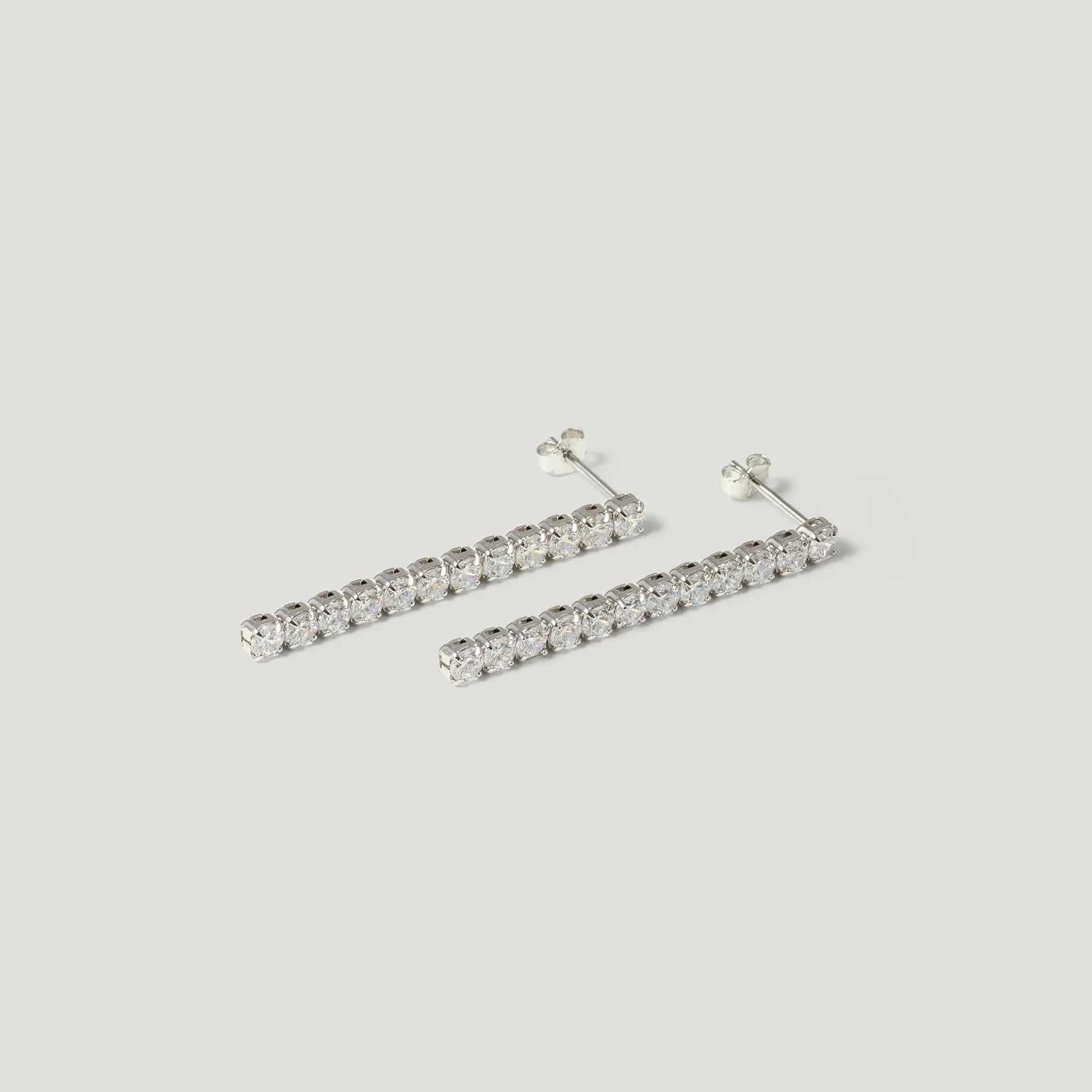 Silver bar stud earrings with clear round gemstones on white background